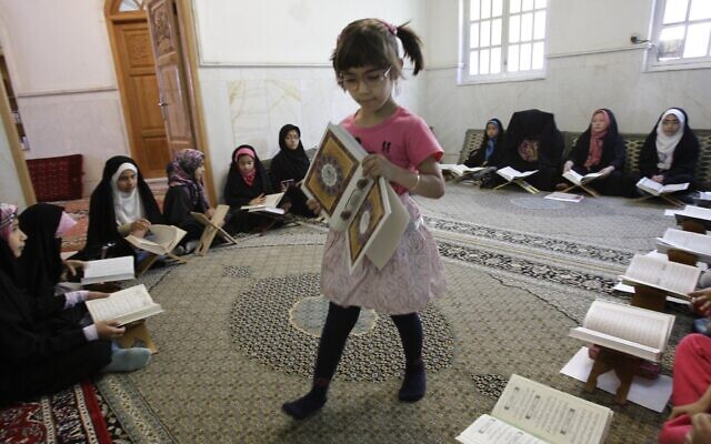 Illustrative: An Iranian girl carries the Quran, Islam's holy book, in a classroom during the Muslim holy fasting month of Ramadan in Tehran, Iran, July 26, 2012. (AP/Vahid Salemi)