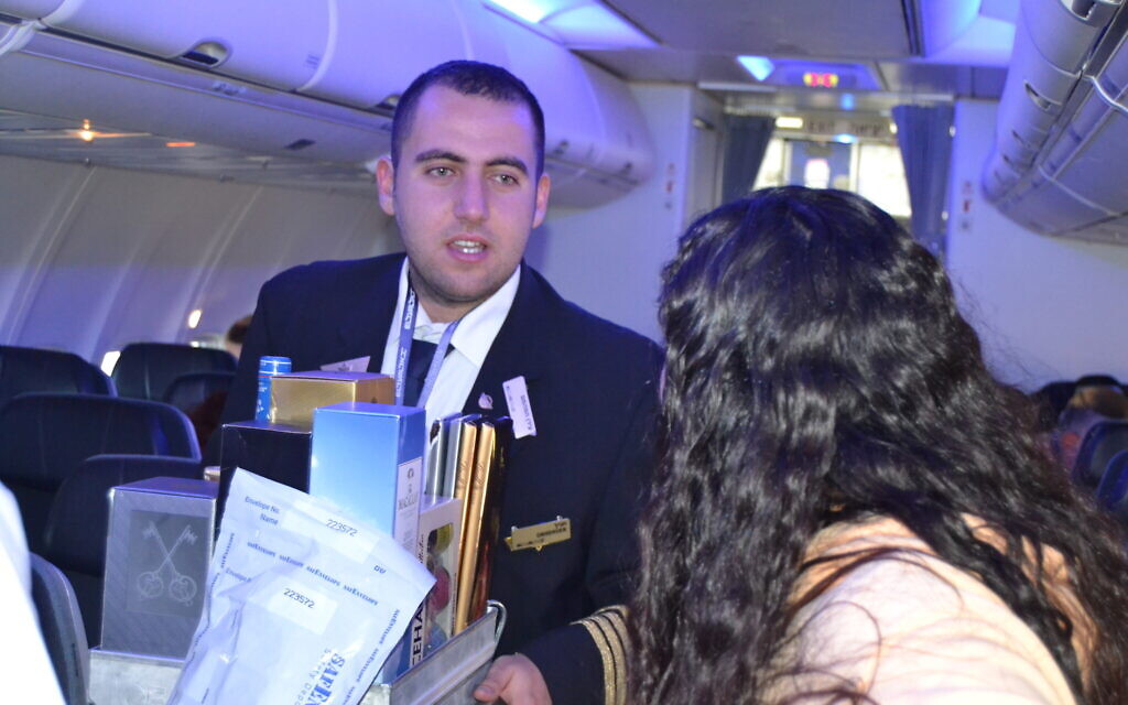 Intrigued passengers ask Idan questions during the flight, February 20, 2023. (Tobias Siegal/The Times of Israel)