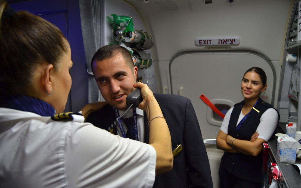 Idan Fishslevich, a 22-year-old with high functioning ASD who was made a flight attendant for one day, makes a voice announcement to passengers onboard El Al's flight LY383 to Rome, Italy, February 20, 2023. (Tobias Siegal/The Times of Israel)