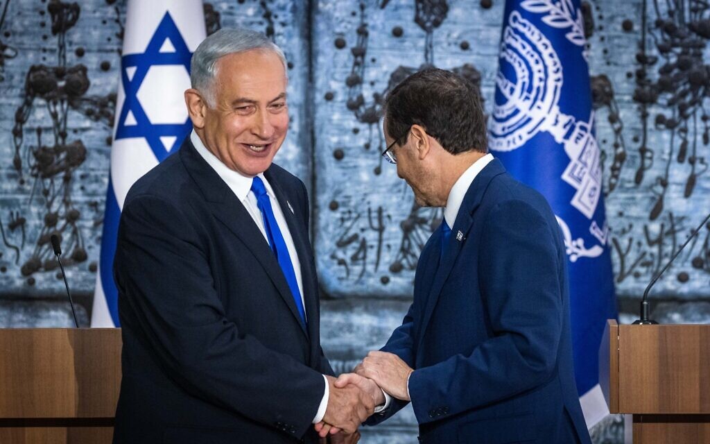 President Isaac Herzog (right) shakes hands with Benjamin Netanyahu after presenting the Likud leader with a mandate to form a new government, at the President's Residence in Jerusalem on November 13, 2022. (Olivier Fitoussi/Flash90)