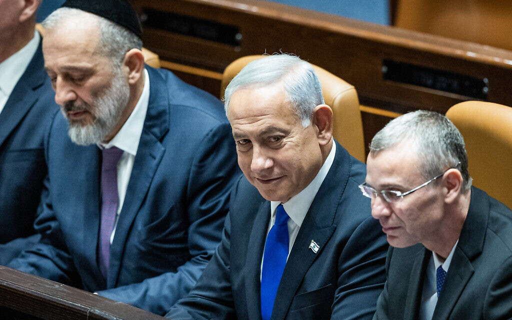 Prime Minister Benjamin Netanyahu with then-Minister of the Interior and Health Aryeh Deri (left) and Justice Minister Yariv Levin (right) during the swearing in ceremony of the new government, at the Knesset, on December 29, 2022. (Yonatan Sindel/Flash90)