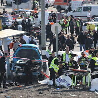 Medics and police officers at the scene of a deadly car-ramming terror attack near the Ramot junction, in Jerusalem on February 10, 2023. (Yonatan Sindel/Flash90)