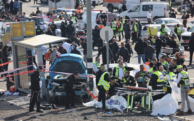 Medics and police officers at the scene of a deadly car-ramming terror attack near the Ramot junction, in Jerusalem on February 10, 2023. (Yonatan Sindel/Flash90)