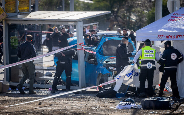 Medics and police officers at the scene of a deadly car-ramming terror attack near Ramot Junction in Jerusalem on February 10, 2023. (Yonatan Sindel/Flash90)