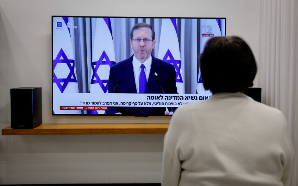 A woman watches President Issac Herzog speech on the proposed changes to the legal system, at a home in Kibbutz Mishmar David, February 12, 2023. (Nati Shohat/Flash90)