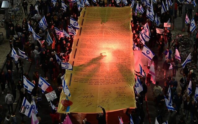 Demonstrators carry a massive Declaration of Independence during a rally in Tel Aviv to protest the Israeli government's overhaul of the judicial system, on February 18, 2023. (Tomer Neuberg/Flash90)