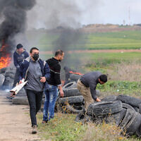 Palestinians burn tires during a protest on the border with Israel, east of Gaza City, February 23, 2023. (Atia Mohammed/Flash90)