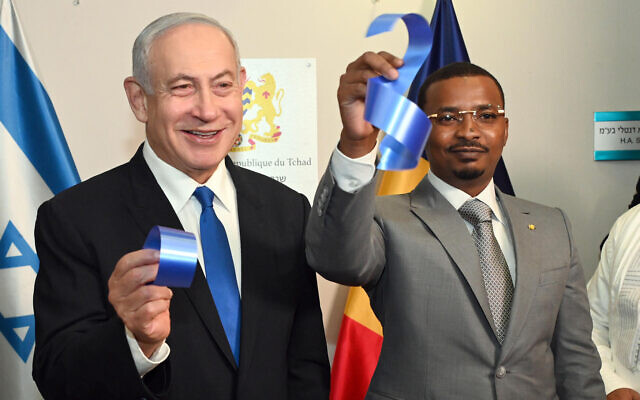 Prime Minister Benjamin Netanyahu (L) and Chad's President Mahamat Idriss Deby Itno hold up pieces of ribbon after a ceremony opening the embassy of Chad in Israel on February 2, 2023 (Haim Zach / GPO)