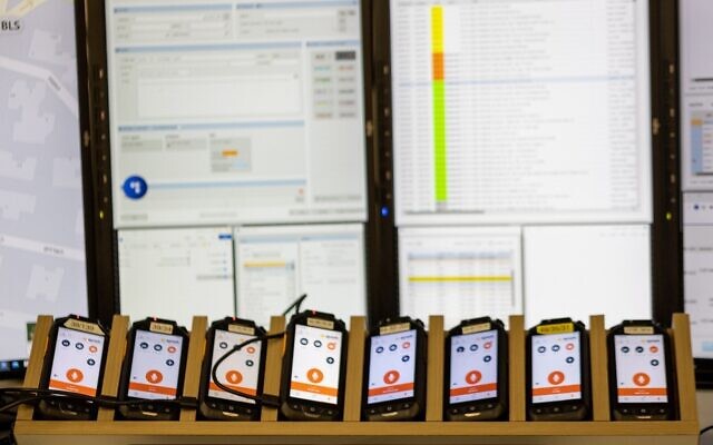 Illustrative: Phones running the SYNCH application developed by Elbit are seen next to a control center screen, in a handout photo published February 8, 2023. (Courtesy)