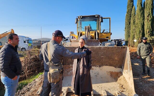 Otzma Yehudit MK Limor Son Har-Melech stands in front of a bulldozer on a plot of land near the settlement of Shiloh in the West Bank to stop the uprooting of trees by the Civil Administration of the Defense Ministry, February 15, 2023. (Office of Limor Son Har Melech)
