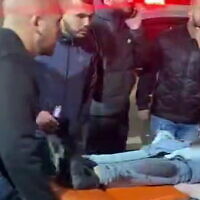 People look on as medics take two men who were shot in the northern town of Jadeidi-Makr to a hospital, February 19, 2023. (Video screenshot: Used in accordance with Clause 27a of the Copyright Law)