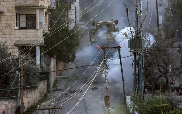 Israeli army vehicles move along a road during a raid in Jenin on March 7, 2023. (Jaafar Ashtiyeh/AFP)