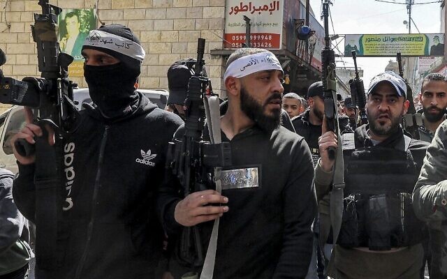 Palestinian gunmen march during the funeral of Abdel Fattah Hussein Kharousha, a Hamas terrorist accused of killing two Israeli brothers in the town of Huwara, at the Askar camp for Palestinian refugees east of Nablus in the West Bank on March 8, 2023. (Zain Jaafar/AFP)