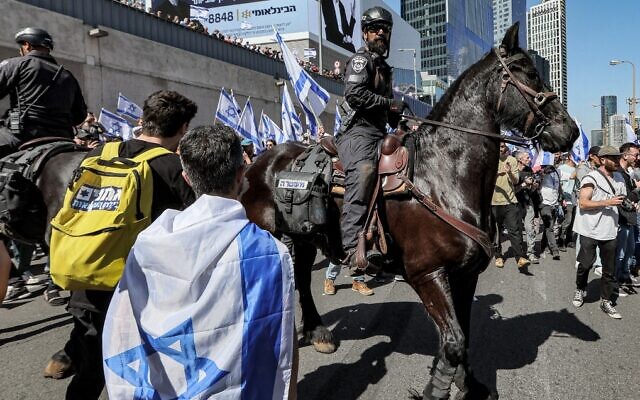 Protestors confront mounted policemen during a demonstration against the government's controversial judicial overhaul measures, in Tel Aviv, March 16, 2023. (Jack Guez/AFP)