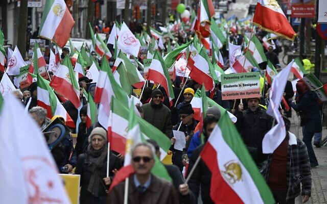 Demonstrators hold Iranian flags during a protest in support of Iranian resistance in front of the European Union headquarters in Brussels on March 20, 2023. (John THYS / AFP)