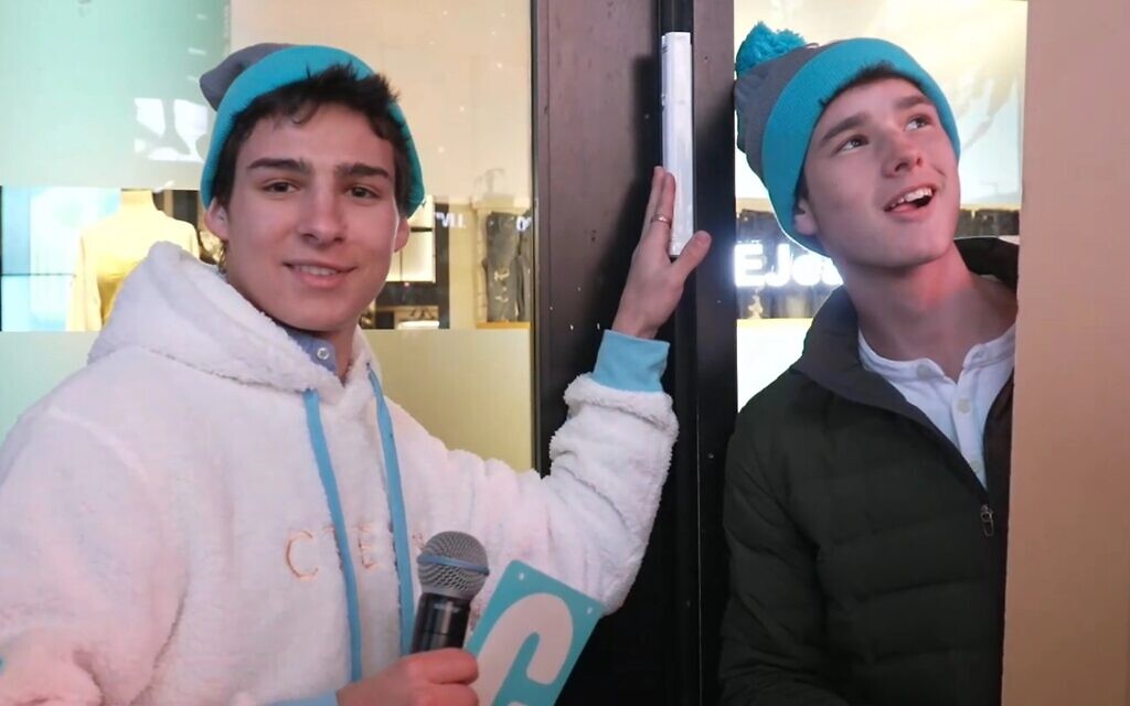Attendees of a Chabad teen convention in Times Square pose next to the mezuzah affixed to the doorpost of American Eagle Outfitters' flagship store. (Courtesy of Chabad via JTA)