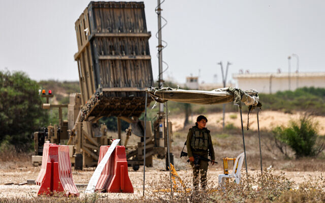 Illustrative: An Israeli soldier stands near an Iron Dome air defense system battery, deployed in southern Israel on August 6, 2022. (Menahem Kahana/AFP)