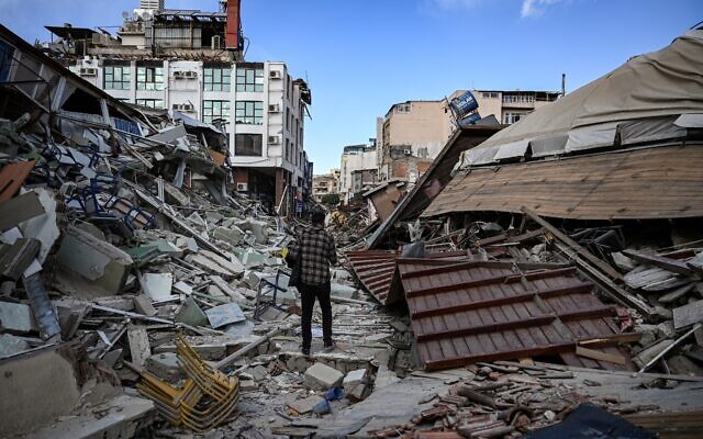 A man walks among the rubble of collapsed buildings in Hatay on March 6, 2023, one month after a massive earthquake struck southeastern Turkey. (OZAN KOSE/AFP)