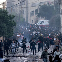 Palestinians in Jenin refugee camp during an Israeli army raid, March 7, 2023. (Jaafar Ashtiyeh / AFP)