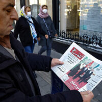 A man in Tehran holds a local newspaper reporting on its front page the China-brokered deal between Iran and Saudi Arabia to restore ties, signed in Beijing the previous day, on March, 11 2023. (ATTA KENARE / AFP)