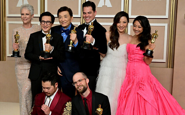 (From L) The cast and crew of 'Everything Everywhere All at Once' Jamie Lee Curtis, Ke Huy Quan, James Hong, Jonathan Wang, Michelle Yeoh, Stephanie Hsu, Daniel Kwan (bottom L), and Daniel Scheinert (bottom R), pose with their Oscar trophies in the press room during the 95th Annual Academy Awards at the Dolby Theatre in Hollywood, California on March 12, 2023. "Everything Everywhere All At Once" producers Daniel Kwan, Daniel Scheinert and Jonathan Wang (Photo by Frederic J. Brown / AFP)