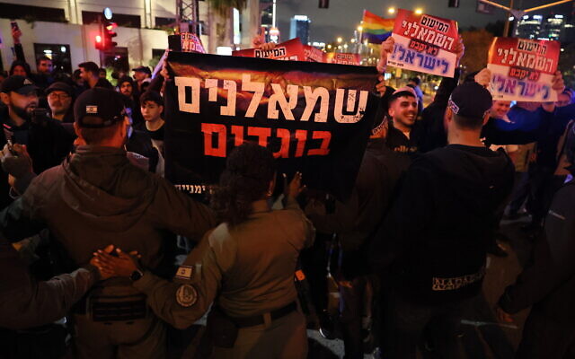 Israeli security forces face off against counter-protesters at a pro-democracy protest against the government's controversial judicial overhaul plans in Tel Aviv on March 18, 2023. The banner at center reads: 'Leftist traitors.' (Jack Guez/AFP)