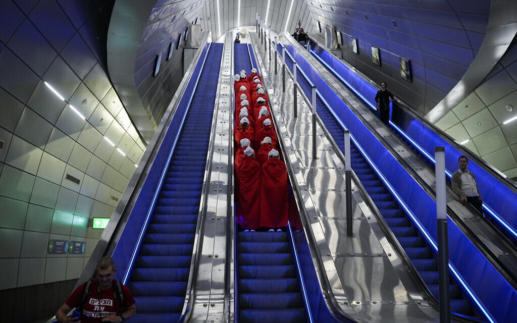 Protesters supporting women's rights dressed as characters from The Handmaid's Tale TV series traveling to a protest against plans by Prime Minister Benjamin Netanyahu's new government to overhaul the judicial system, at a railway station in Jerusalem, March 1, 2023. (AP Photo/Ohad Zwigenberg)