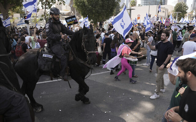 Mounted police push Israelis blocking a road during a protest against plans by Prime Minister Benjamin Netanyahu's government to overhaul the judicial system, in Tel Aviv, March 1, 2023. (AP Photo/Oded Balilty)