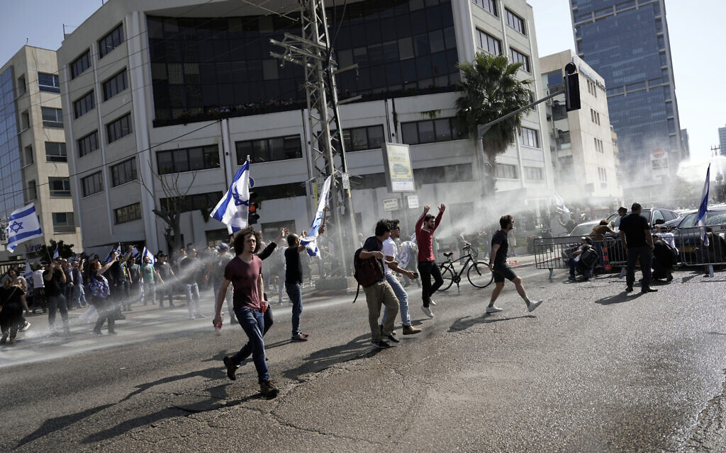 Israeli police deploy a water cannon to disperse Israelis blocking a main road to protest against plans by Prime Minister Benjamin Netanyahu's new government to overhaul the judicial system, in Tel Aviv, Israel, Wednesday, March 1, 2023. (AP Photo/Oded Balilty)