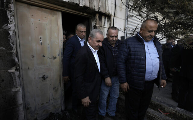 Palestinian Authority Prime Minister Mohammad Shtayyeh (L) visits an apartment damaged by fires from torched vehicles during a rampage by settlers in the West Bank town of Huwara, March 1, 2023. (AP/Majdi Mohammed)