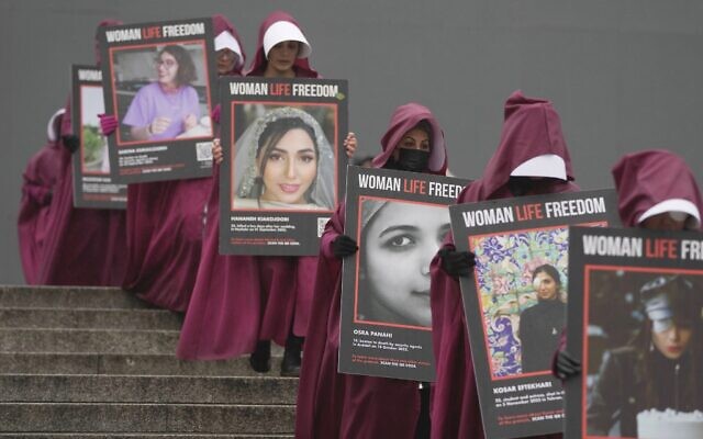 Activists hold placards reading "Woman, Life, Freedom" with portraits of women who were killed in Iran, during a demonstration to mark the International Women's Day, in London, March 8, 2023. (AP Photo/Kin Cheung)