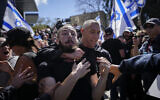 Police scuffle with protesters during a protest against plans by Prime Minister Benjamin Netanyahu's new government to overhaul the judicial system, in Tel Aviv, March 9, 2023. (AP Photo/Ohad Zwigenberg)