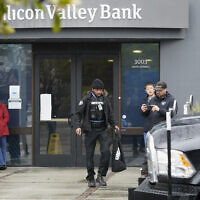 A Brinks worker walks toward a truck after exiting Silicon Valley Bank in Santa Clara, Calif., Friday, March 10, 2023. The U.S rushed to seize the assets of Silicon Valley Bank on Friday after a run on the bank, the largest failure of a financial institution since Washington Mutual during the height of the financial crisis more than a decade ago. (AP Photo/Jeff Chiu)
