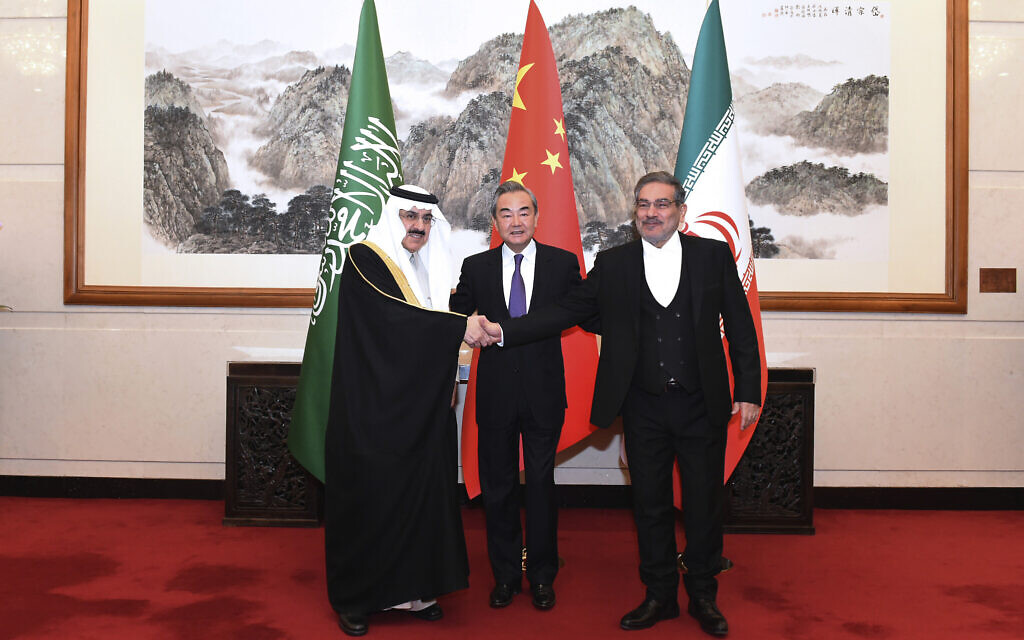 In this photo released by Xinhua News Agency, Ali Shamkhani, the secretary of Iran's Supreme National Security Council, at right, shakes hands with Saudi national security adviser Musaad bin Mohammed al-Aiban, at left, as Wang Yi, China's most senior diplomat, looks on, at center, for a photo during a closed meeting held in Beijing, March 11, 2023. (Luo Xiaoguang/Xinhua via AP)