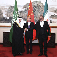 In this photo released by Xinhua News Agency, Ali Shamkhani, the secretary of Iran's Supreme National Security Council, at right, shakes hands with Saudi national security adviser Musaad bin Mohammed al-Aiban, at left, as Wang Yi, China's most senior diplomat, looks on, at center, for a photo during a closed meeting held in Beijing, March 11, 2023. Iran and Saudi Arabia agreed Friday to reestablish diplomatic relations and reopen embassies after seven years of tensions. The major diplomatic breakthrough negotiated with China lowers the chance of armed conflict between the Mideast rivals, both directly and in proxy conflicts around the region. (Luo Xiaoguang/Xinhua via AP)