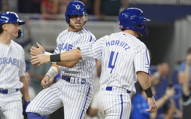 Israel's Spencer Horwitz (4) and Noah Mendlinger celebrate after scoring on a hit by Garrett Stubbs during the eighth inning of a World Baseball Classic game against Nicaragua, Sunday, March 12, 2023, in Miami. (AP/Marta Lavandier)