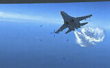 This photo taken from video released on Thursday, March 16, 2023, shows a Russian Su-27 approaching the back of the MQ-9 drone and beginning to release fuel as it passes, over the Black Sea, the Pentagon said.  (US Department of Defense via AP)