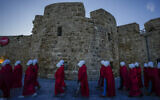 Protesters supporting women's rights dressed as characters from "The Handmaid's Tale" TV series attend a protest against the government's plans to overhaul the judicial system in the old port of Acre in northern Israel, March 16, 2023. (AP/Ariel Schalit)