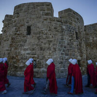 Protesters supporting women's rights dressed as characters from "The Handmaid's Tale" TV series attend a protest against the government's plans to overhaul the judicial system in the old port of Acre in northern Israel, March 16, 2023. (AP/Ariel Schalit)