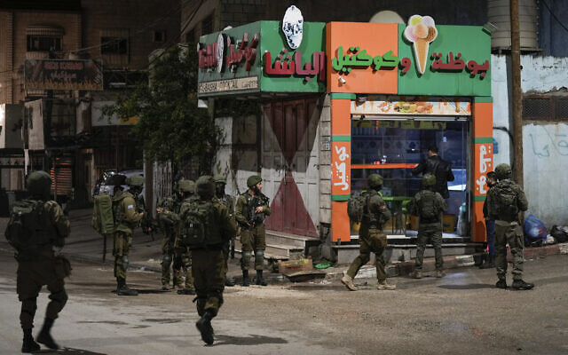 Israeli soldiers are deployed at the scene where a Palestinian gunman opened fire at soldiers in the West Bank town of Huwara, March 25, 2023. (AP Photo/Majdi Mohammed)