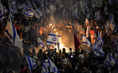 Israelis opposed to Prime Minister Benjamin Netanyahu's judicial overhaul plan set up bonfires and block a highway during a protest moments after the Israeli leader fired his defense minister, in Tel Aviv, Israel, March 26, 2023. (AP Photo/Ohad Zwigenberg)