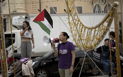 A woman waves the Palestinian flag at a demonstration by left-wing Israelis in solidarity with Palestinians as part of ongoing protests against plans by Prime Minister Benjamin Netanyahu's government to overhaul the judicial system, in Jaffa, March 23, 2023. (AP Photo/Maya Alleruzzo)