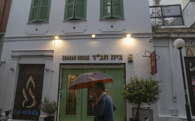 A man holding an umbrella walks past a Jewish restaurant that Greek officials believe was one of the targets of a planned terrorist attack, in central Athens, Tuesday, March 28, 2023. (AP Photo/Thanassis Stavrakis)