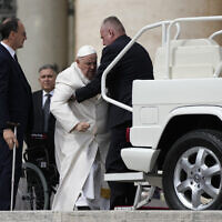 Pope Francis helped to get on his car at the end of weekly general audience in St. Peter's Square, at the Vatican, March 29, 2023. (AP Photo/Alessandra Tarantino)