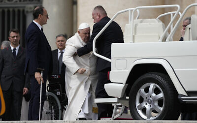 Pope Francis helped to get on his car at the end of weekly general audience in St. Peter's Square, at the Vatican, March 29, 2023. (AP Photo/Alessandra Tarantino)