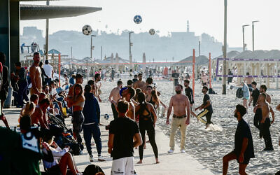 Israelis enjoy the beach in Tel Aviv on a hot winter day, January 21, 2023. (Avshalom Sassoni/Flash90)