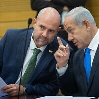 Prime Minister Benjamin Netanyahu , right, converses with Knesset Speaker Amir Ohana during a Likud faction meeting on February 6, 2023. (Yonatan Sindel/Flash90)