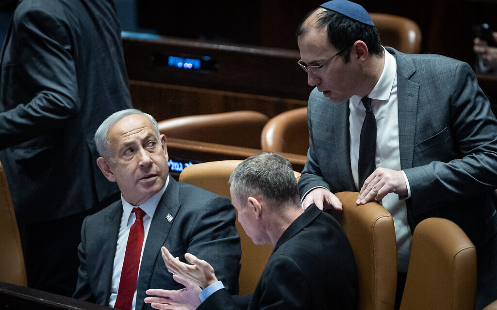 Prime Minister Benjamin Netanyahu (left) with Justice Minister Yariv Levin and MK Simcha Rothman (standing) in the Knesset on February 15, 2023. (Yonatan Sindel/Flash90)