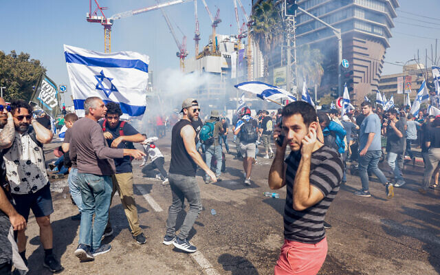 Demonstrators block a road and clash with police who deploy tear gas as they protest against the government's planned judicial overhaul, in Tel Aviv, March 1, 2023. (Erik Marmor/Flash90)