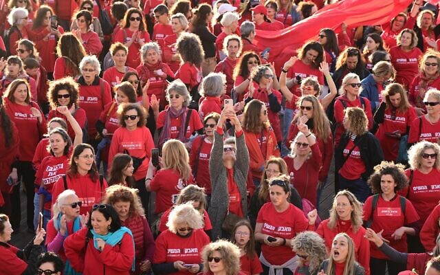 Hundreds of women dressed in red mark International Women's Day and demonstrate against the government's planned judicial overhaul, on the beach in Tel Aviv, March 8, 2023. (Tomer Neuberg/Flash90)
